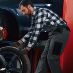 side-view-moving-tire-car-man-uniform-is-working-auto-salon