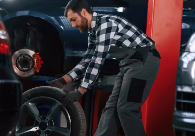 side-view-moving-tire-car-man-uniform-is-working-auto-salon